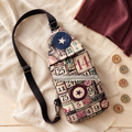 Bingo-print handmade sling bag with adjustable black strap displayed beside vintage bingo markers