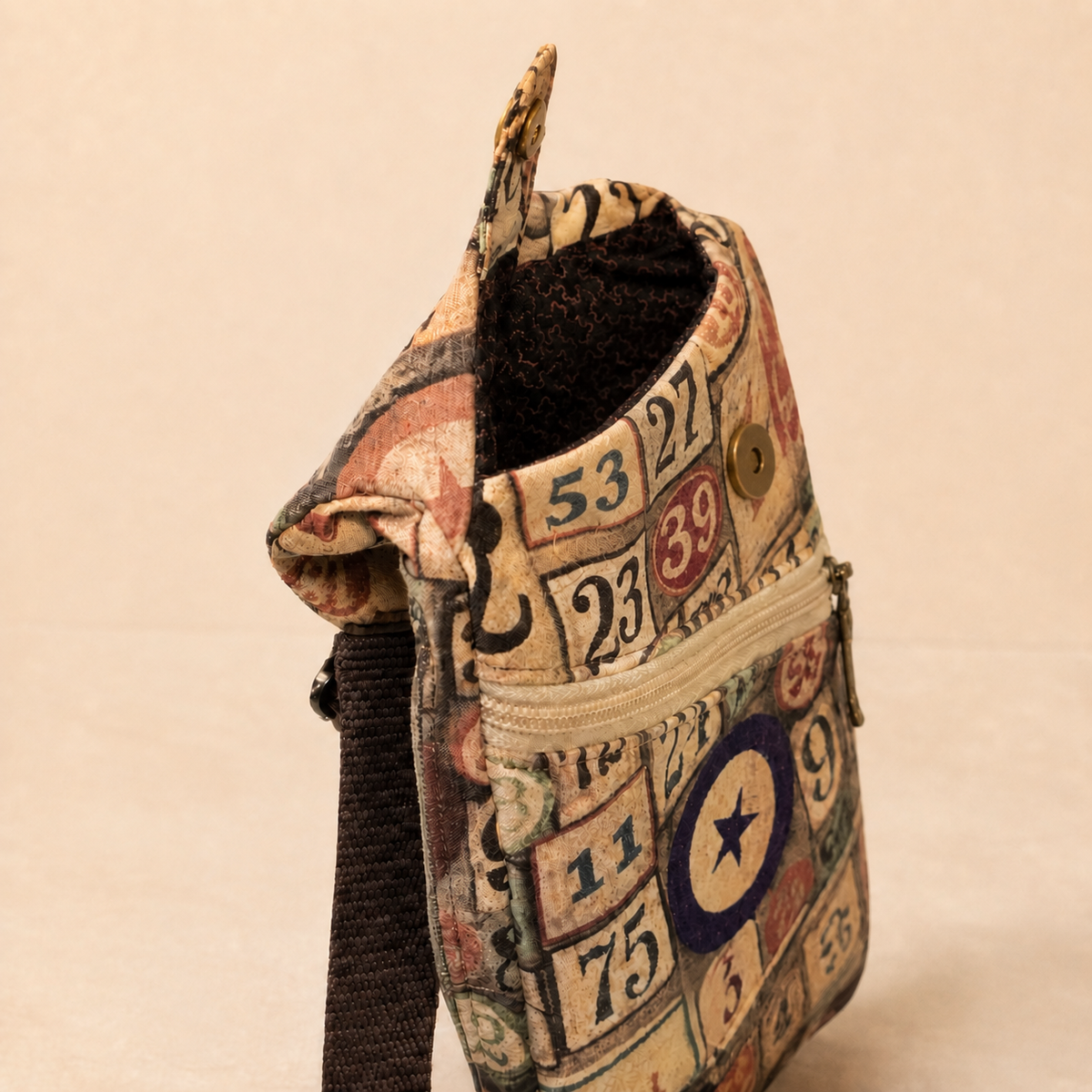Open bingo-print sling bag showing the interior and exterior zipper pocket